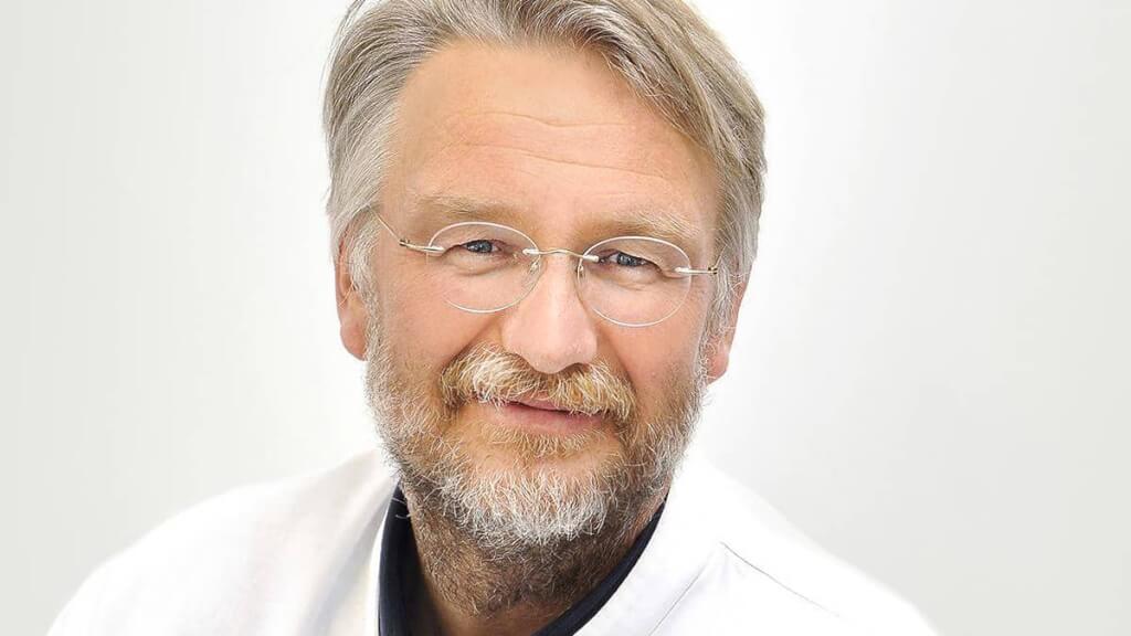 Ausdrucksstarkes und nahbares Portrait eines Arztes mit Brille, erstellt für den professionellen Internetauftritt einer Klinik in Wuppertal