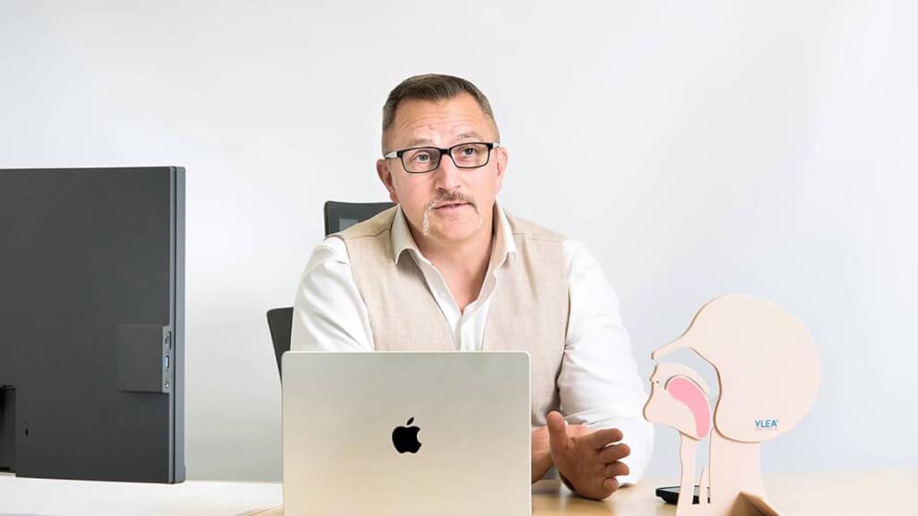 Professionelles Portrait eines Geschäftsführers am Laptop in einer authentischen Beratungssituation während einer B2B-Unternehmens-Reportage