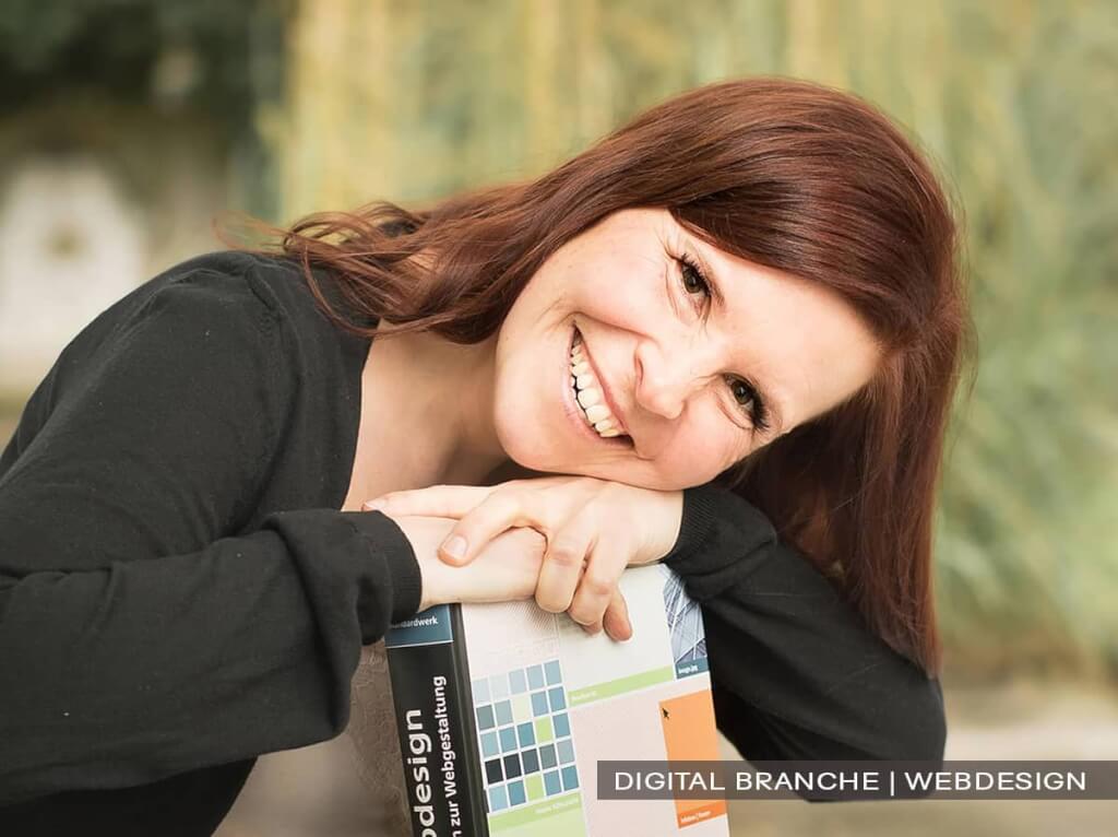 Sympathisches Personal-Branding-Portrait einer Webdesignerin mit einem WordPress-Handbuch, authentisch und nahbar fotografiert in Wuppertal von Josephine Scharrer