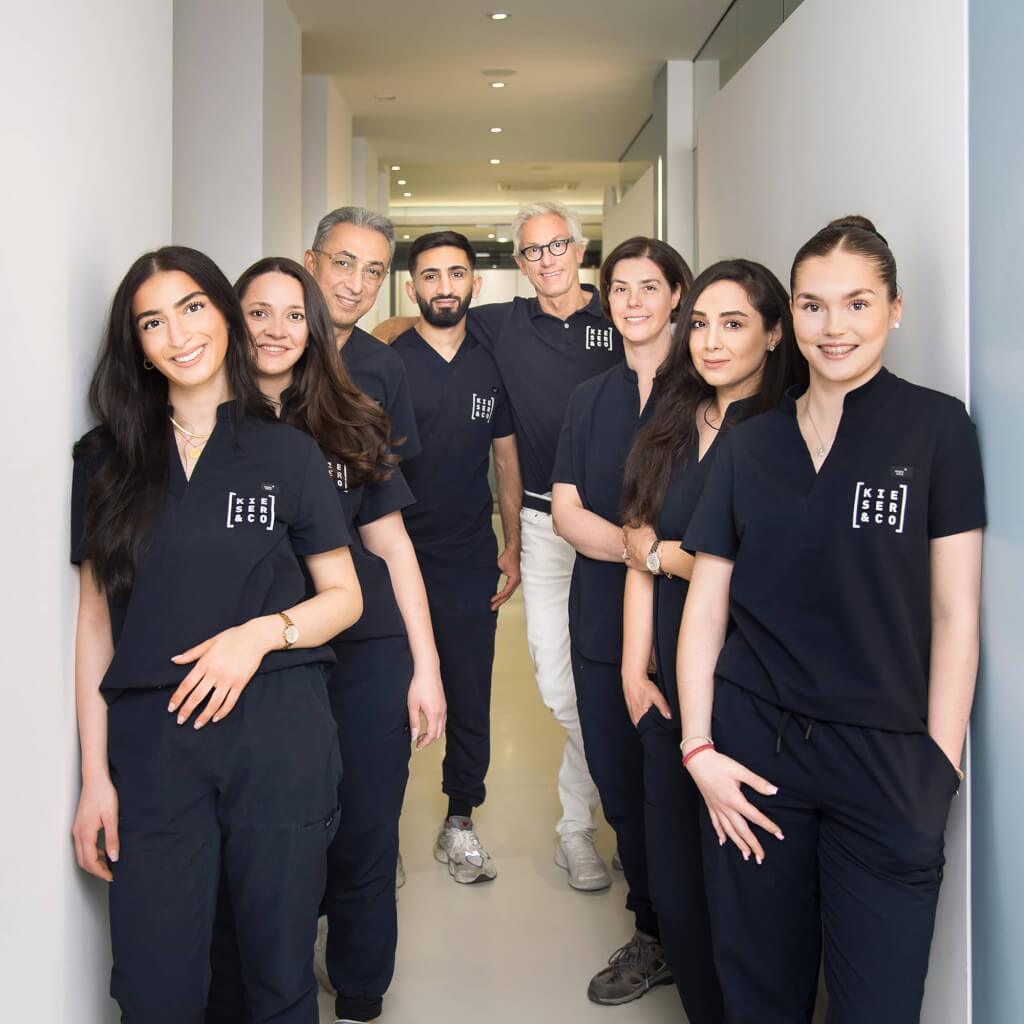 Dynamisches Gruppenbild des gesamten Praxisteams von Kieser & Co. Kieferorthopäden im modernen Praxisflur in Wuppertal, fotografiert von Businessfotografin Josephine Scharrer